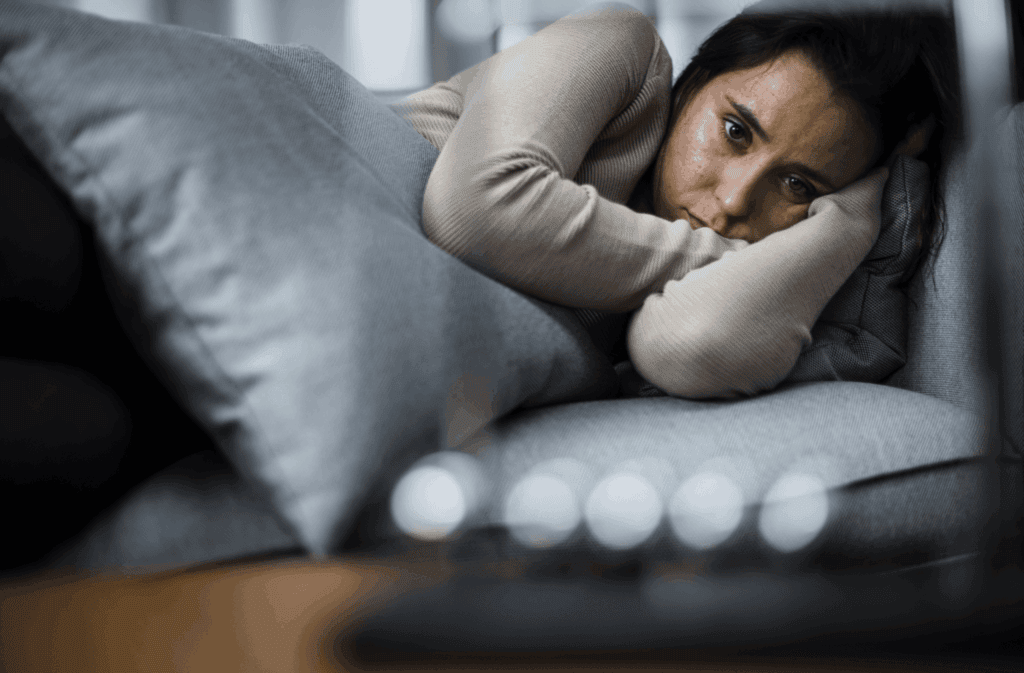 An image of a female lying in bed unable to sleep, one of the symptoms of low mood.