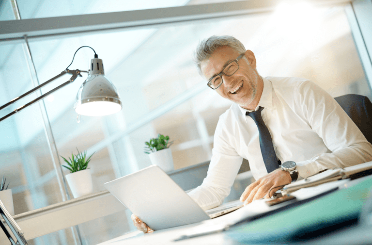 An image of a male worker smiling in their office