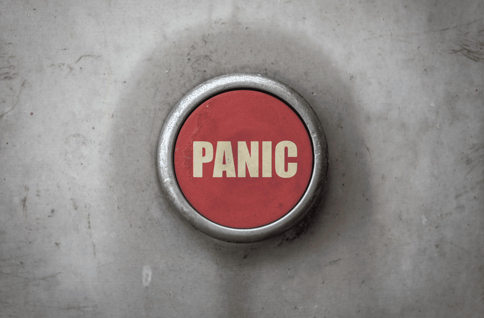 The image shows a red button with white writing saying panic in capital letters.