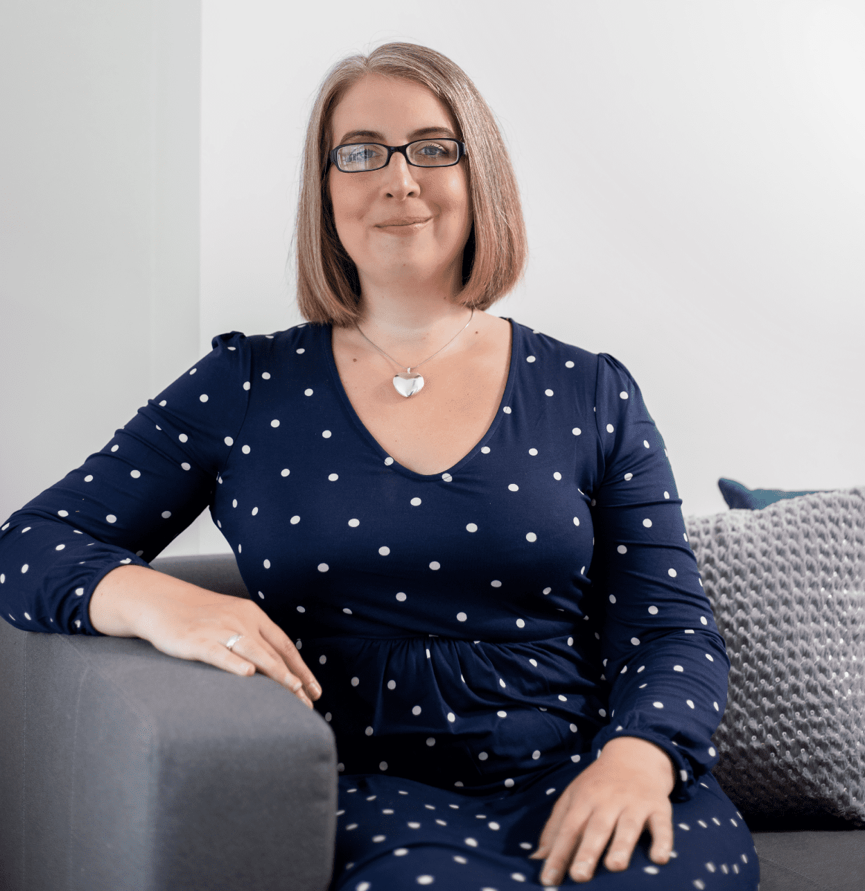 A photo of me, Hannah Paskin. I'm sat on a Therapy Sofa in my Therapy room in Middlewich.