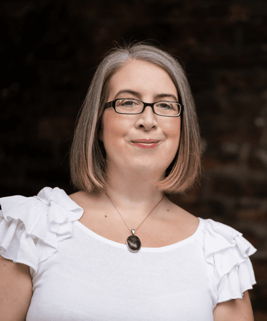 Hannah Paskin wearing glasses and a white shirt.