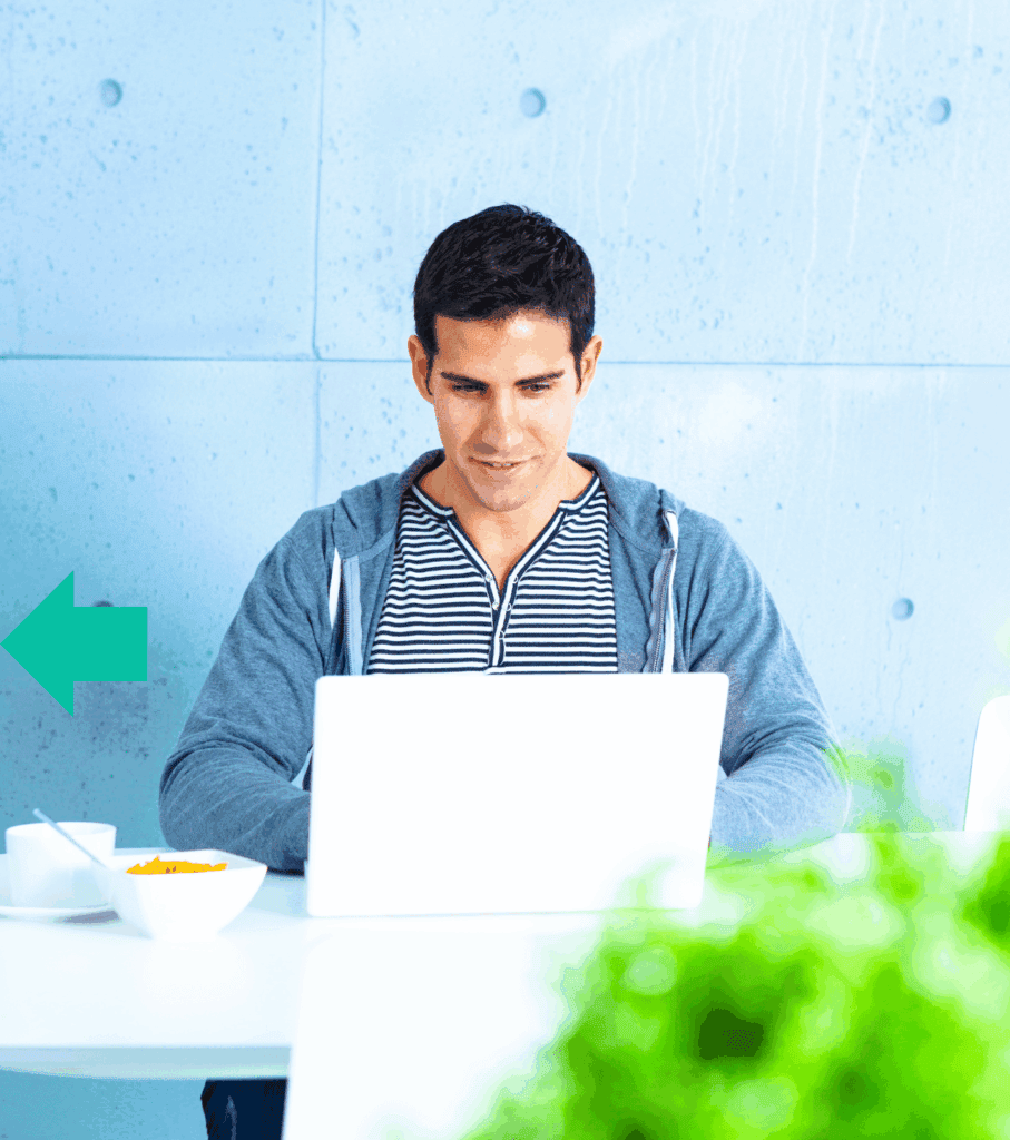 Young man focused on his laptop in a modern workspace.