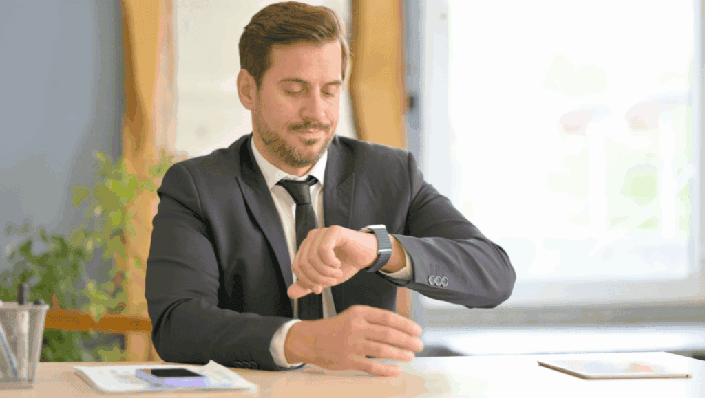 A professional man in a suit checking his smartwatch in a modern office.