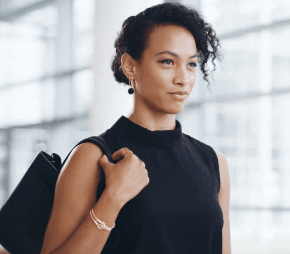 A confident woman wearing a black outfit, showcasing a stylish look.