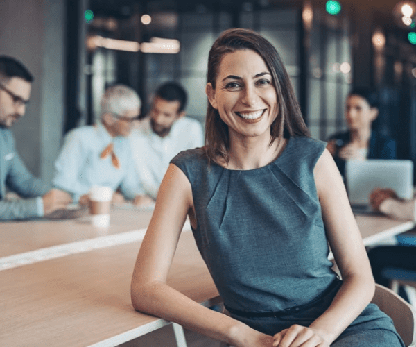 Smiling female professional in casual attire, representing a friendly work environment.