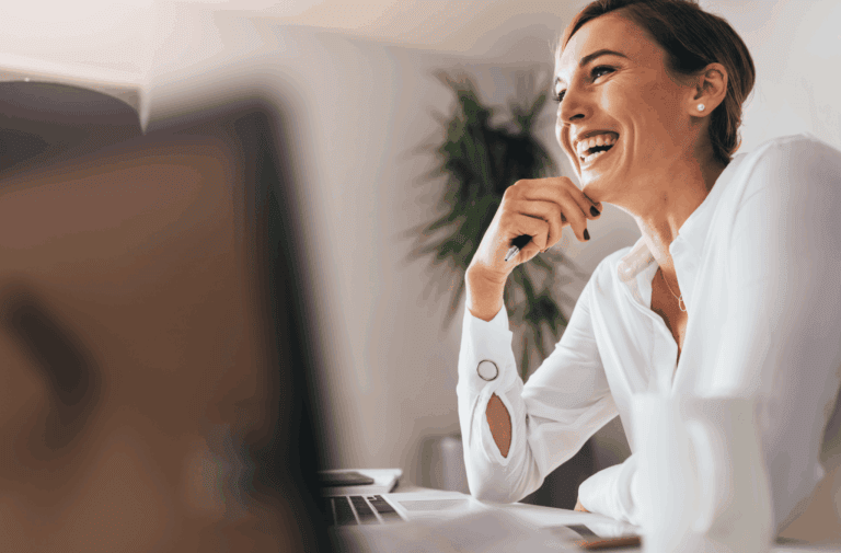 A happy businesswoman in a white shirt, engaged in a conversation at her office.