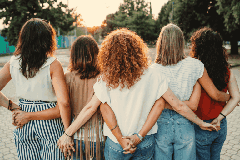 Group of women walking together at sunset, showcasing friendship and connection.